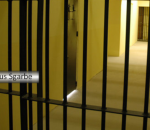Corredor de uma prisão com grades em várias portas