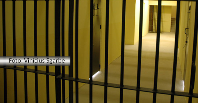 Corredor de uma prisão com grades em várias portas