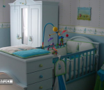Quarto de bebê em que aparece o berço, com enfeites e brinquedos pendurados, com roupeiro e gaveteiro