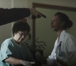 Médica e enfermeiras prestando atendimento em hospital com uma arma apontada para o rosto de uma delas