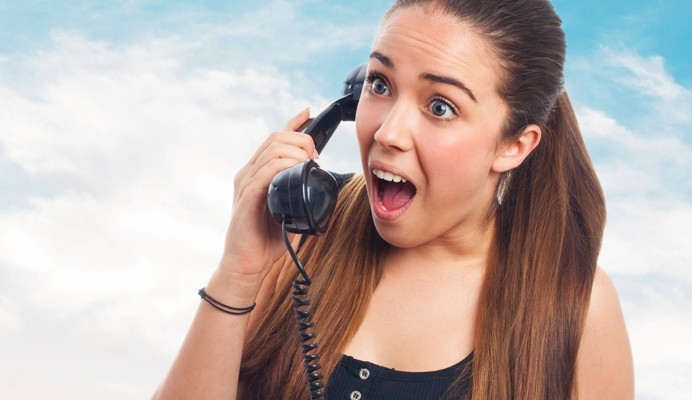 moça ao telefone com expressão surpresa e chocada representa um cliente mal atendido
