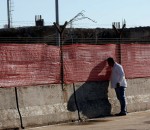 Homem espia pelo tapume do aeroporto Salgado Filho. Foto: JOão Mattos Fotografia
